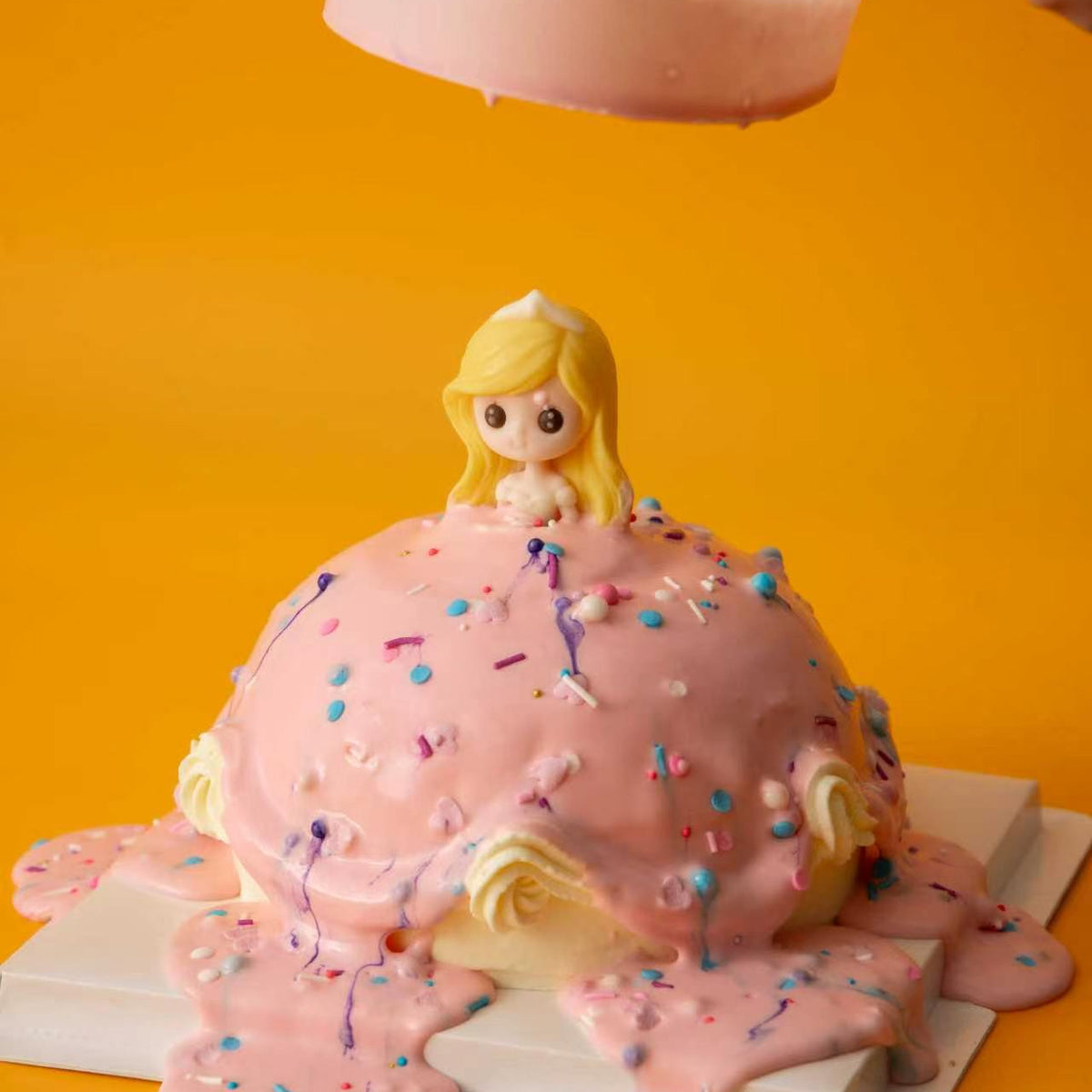 Lifting the clear collar from the finished Pour & Sprinkle Princess Cake