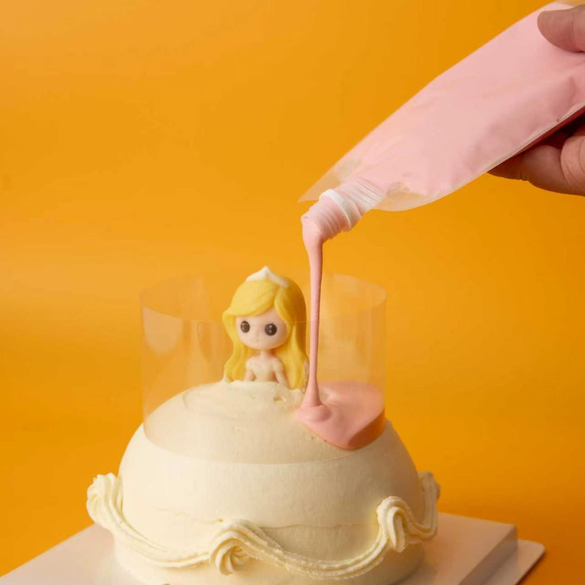 Pouring pink glaze onto the Pour & Sprinkle Princess Cake