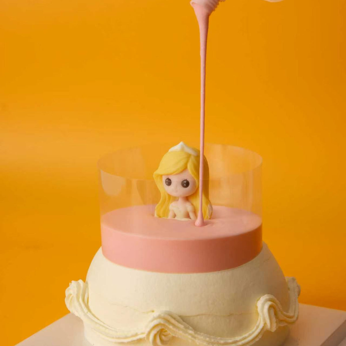Pink glaze filling the clear collar around the Princess Cake