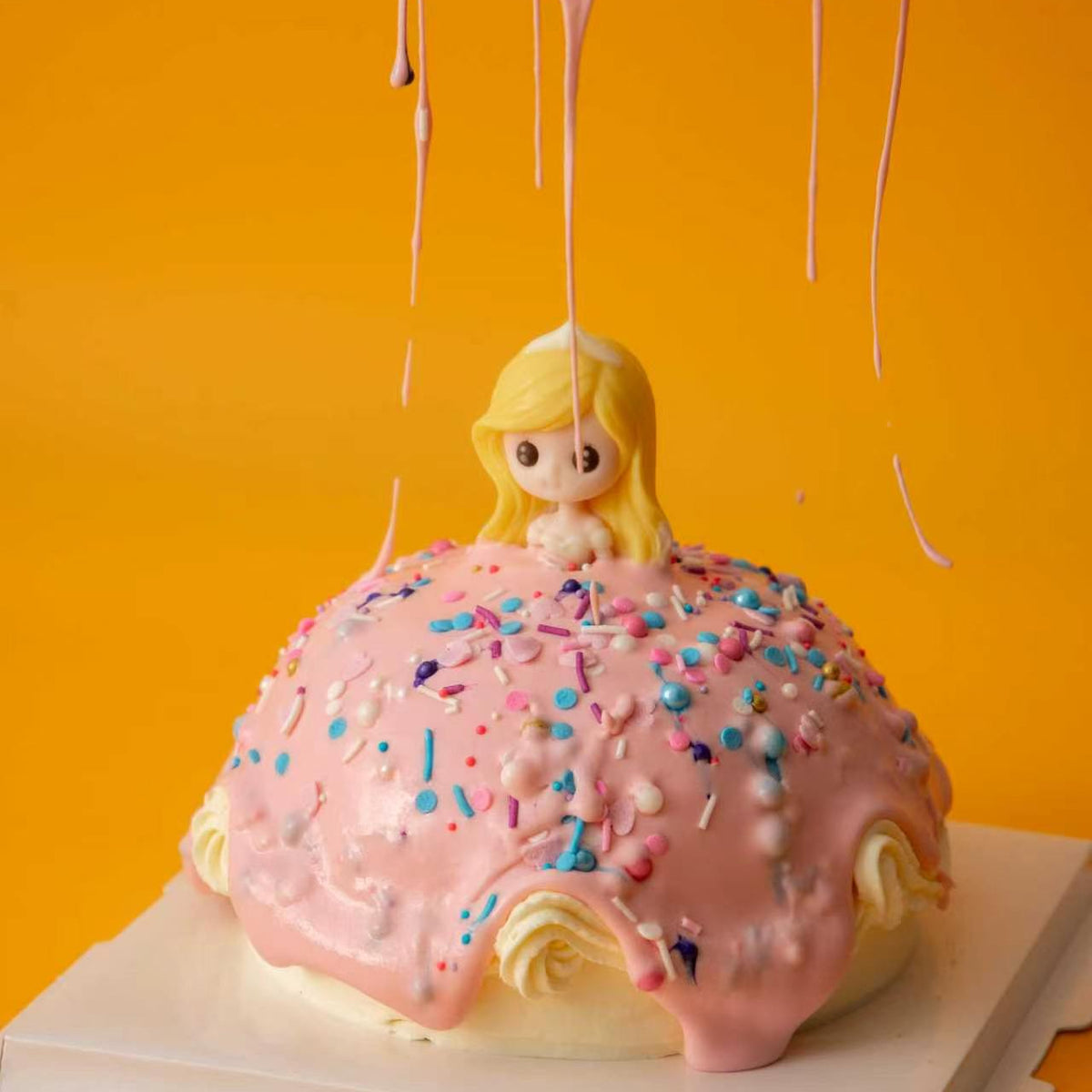 Pink glaze dripping over the decorated Princess Cake